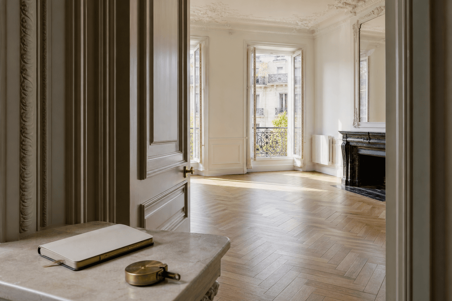 Appartement parisien lumineux observé depuis une entrée avec carnet et mètre prêts pour la visite
